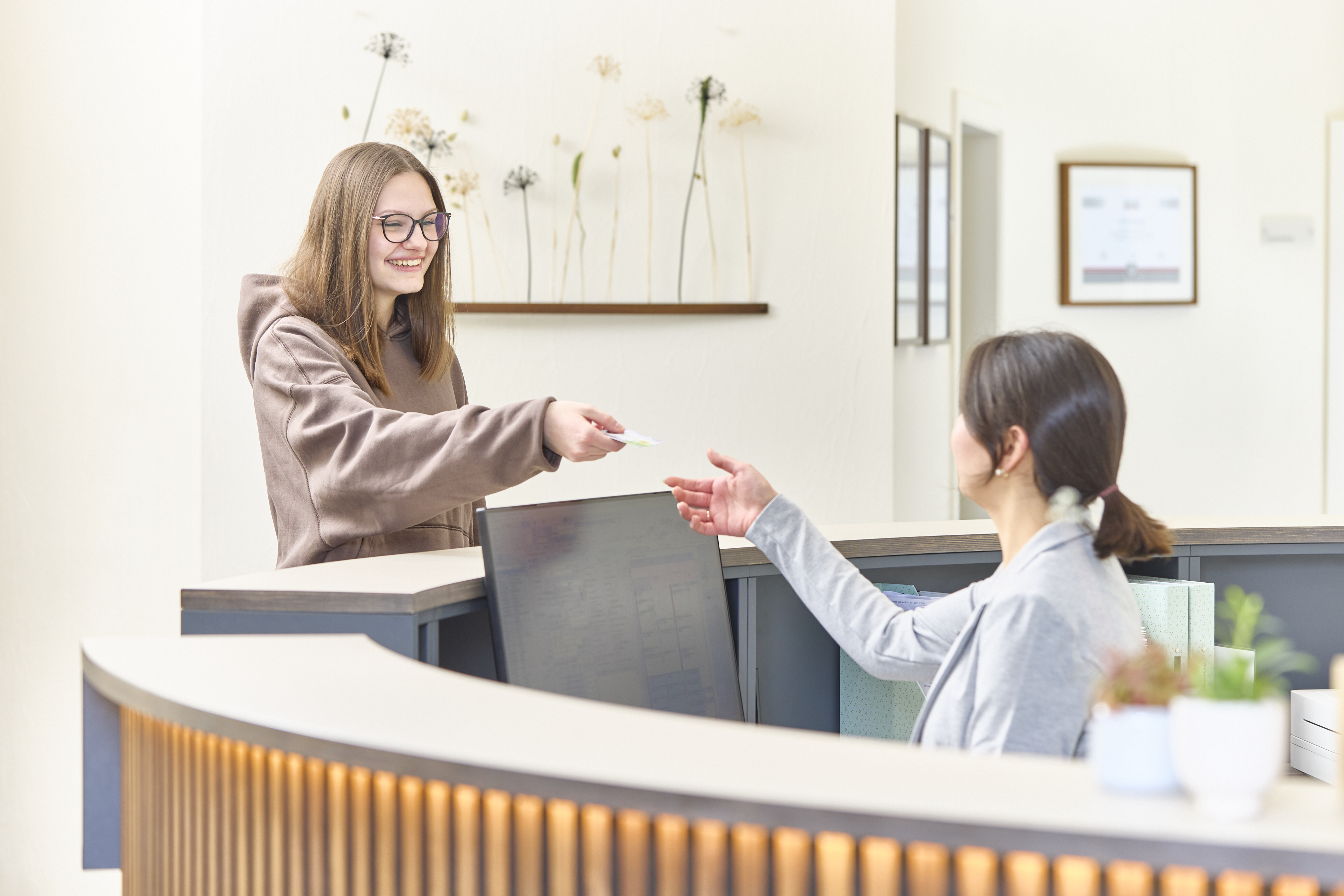 Patientin überreicht Versichertenkarte