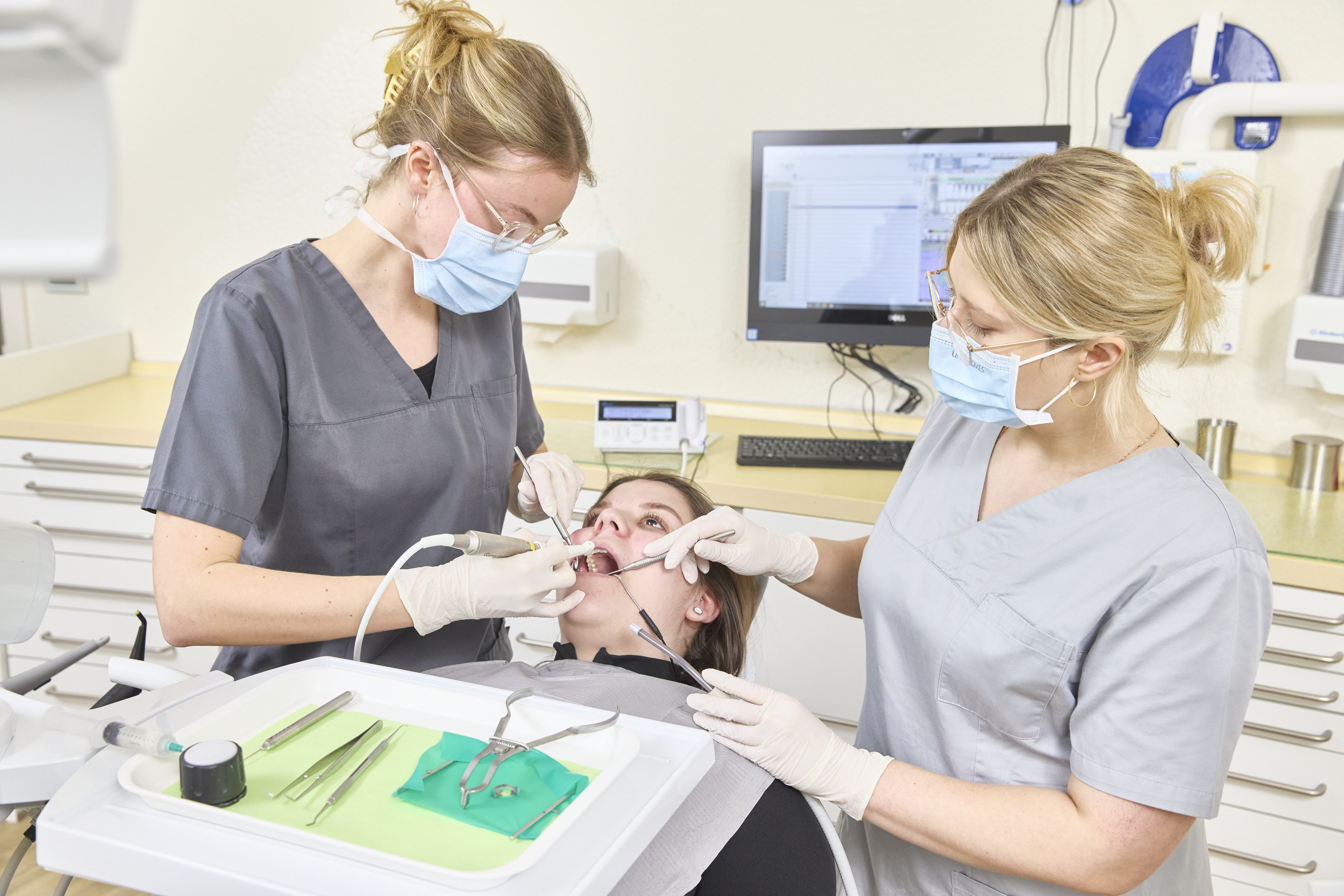 Zahnärztin und Assistentin behandeln eine Patientin
